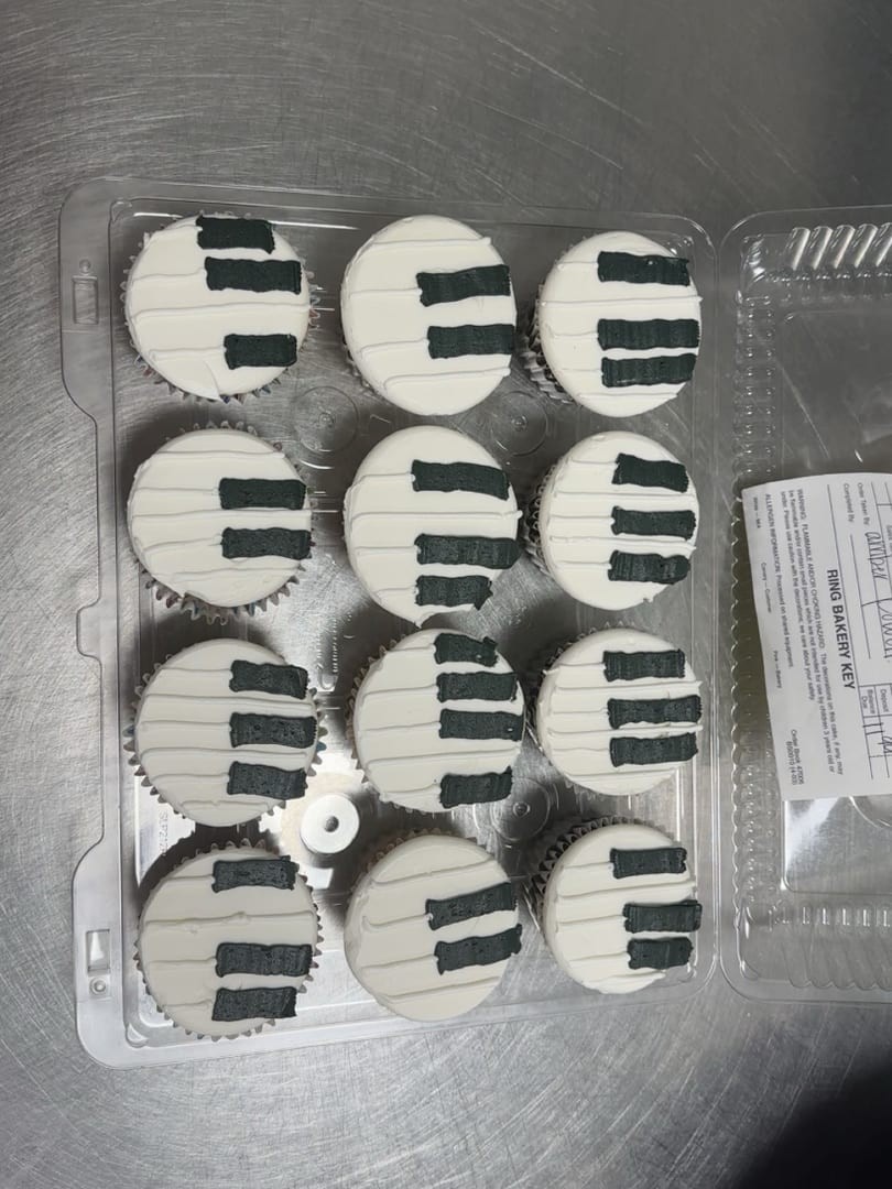 Twelve cupcakes decorated like black and white piano keys