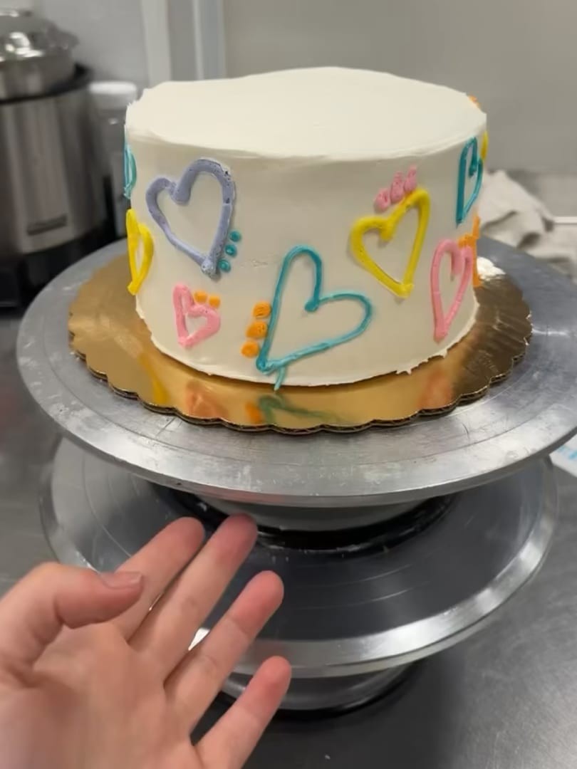 White cake with colorful hand-piped heart outlines
