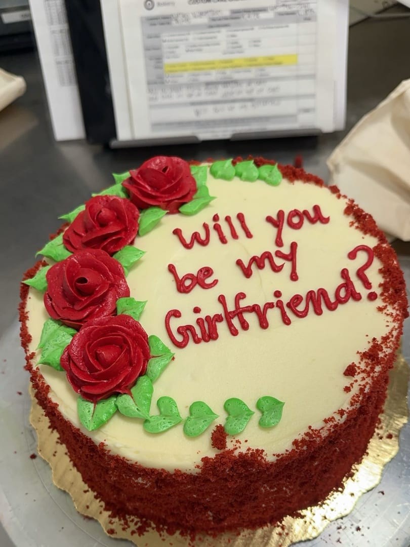 Red velvet cake with red buttercream roses and green leaves