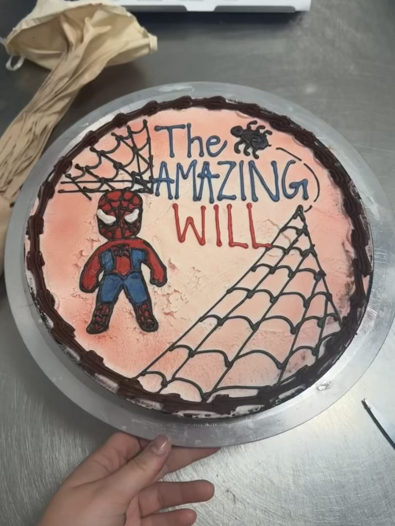Round cake painted with a Spider-Man figure and a web